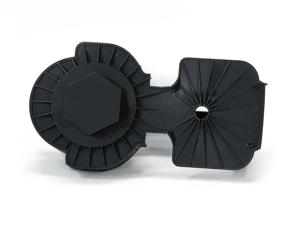 Schwarze Gehäuseabdeckung aus ABS110 mit Verrippung, Sechskantaufnahme und zwei Schraubdomen.