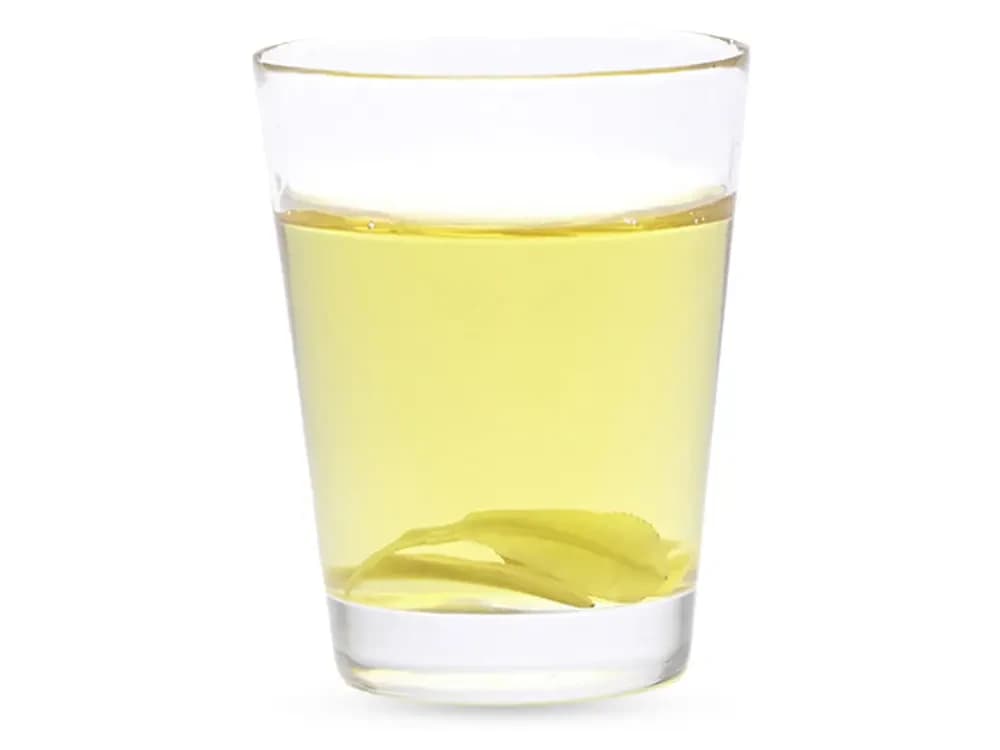 Glas mit hellgelbem Crys100-Harz, am Boden liegt ein transparentes gedrucktes Bauteil.