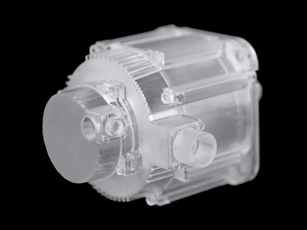 Transparentes Motorgehäuse aus Cryscast 2101 mit umlaufenden Kühlrippen und angeformten Anschlüssen.