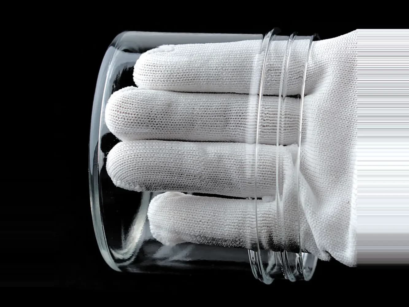 Eine Hand im weißen Handschuh, gesehen durch einen glasklaren Zylinder aus Crysplus 1801.