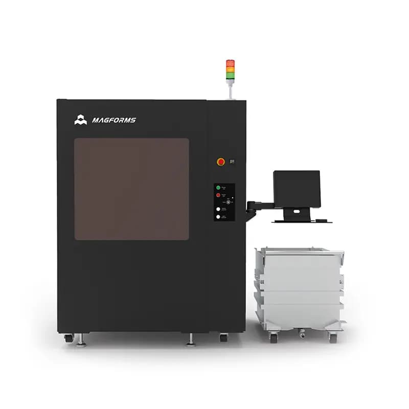 Schwarze industrielle Maschine mit dem Schriftzug Magforms, einem Monitor und einem weißen Behälter auf Rollen.