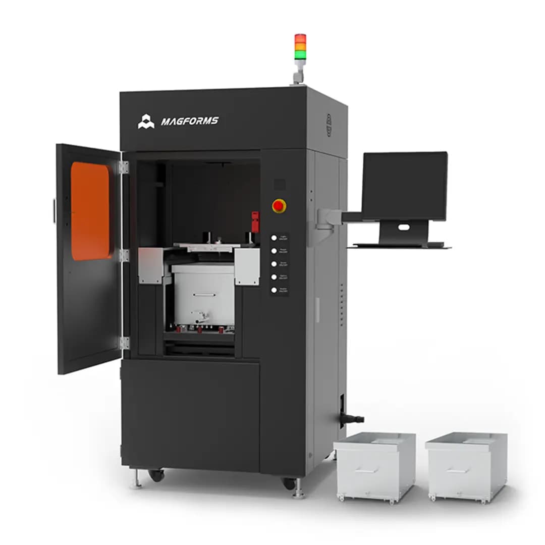 Schwarze industrielle Magforms-Maschine mit geöffnetem Fach, Monitor an der Seite und zwei weißen Schubladen auf Rollen daneben.
300x300x300mm