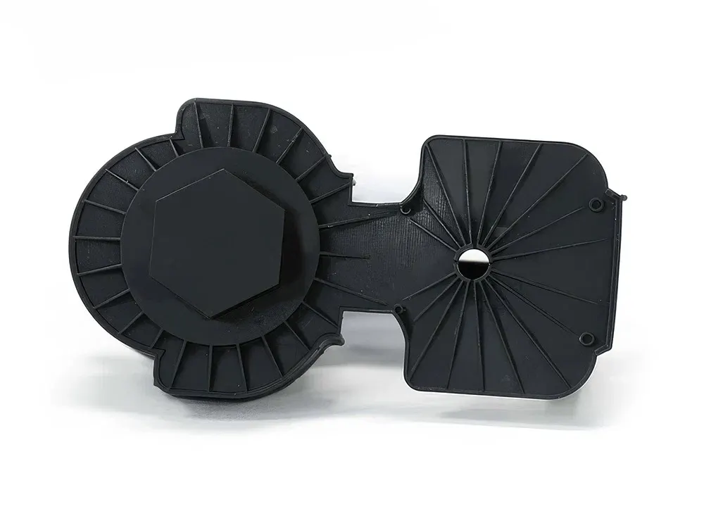 Schwarze Gehäuseabdeckung aus ABS110 mit Verrippung, Sechskantaufnahme und zwei Schraubdomen.