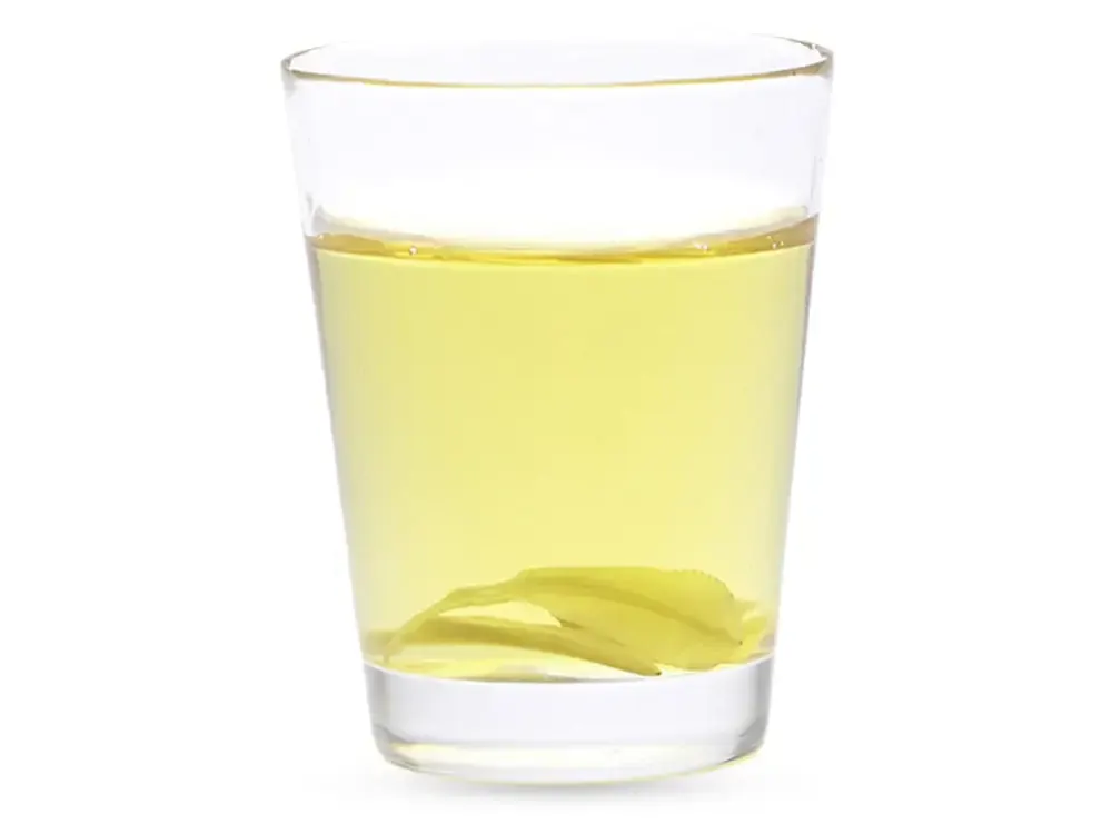 Glas mit hellgelbem Crys100-Harz, am Boden liegt ein transparentes gedrucktes Bauteil.