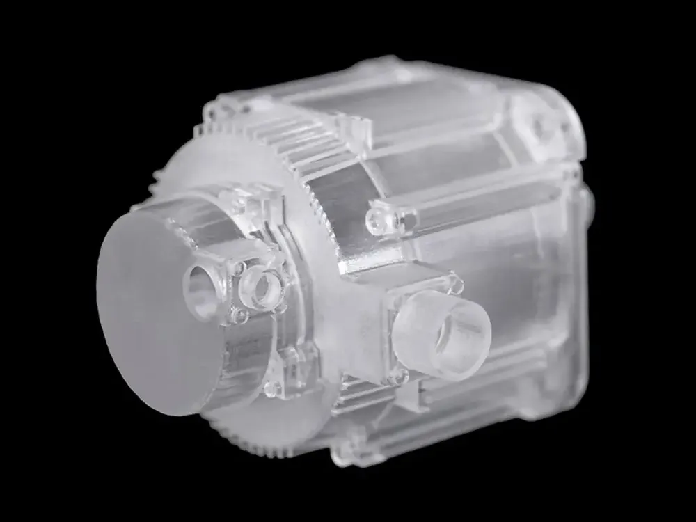 Transparentes Motorgehäuse aus Cryscast 2101 mit umlaufenden Kühlrippen und angeformten Anschlüssen.